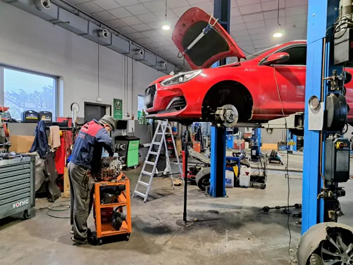 Czerwone auto na podnośniku w hali