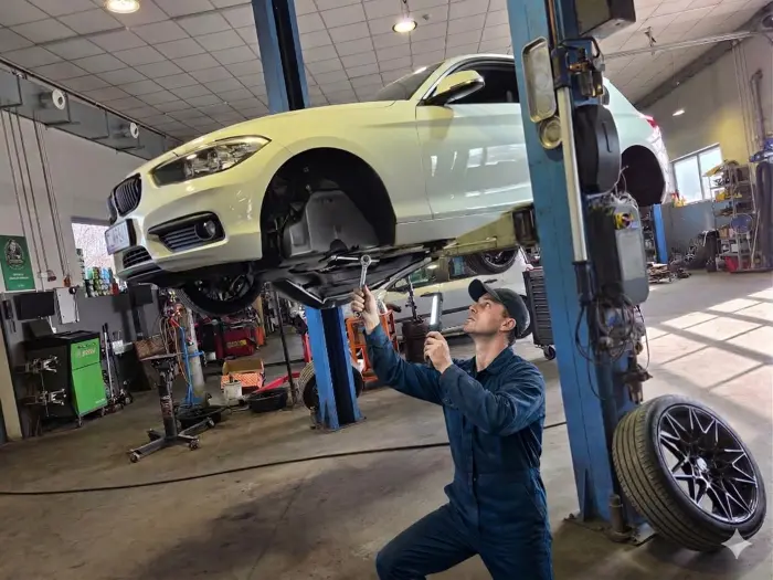 Mechanik przy kole BMW na podnośniku