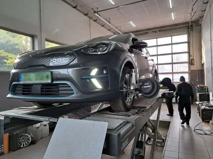 Kia na stanowisku geometrii, mechanicy w tle