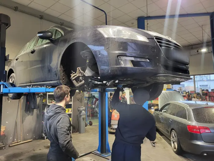 Dwóch mechaników przy zawieszeniu auta